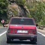 Ayaklarını camdan sarkıtarak trafiği tehlikeye attı