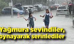 Yağmura sevindiler, yağış altında oynayarak serinlediler