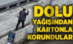 Dolu yağışından kafalarına karton koyarak korundular