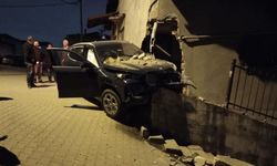 Otomobil, yıktığı istinat duvarında asılı kaldı