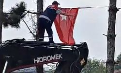 İş makinesinin üzerine çıkıp Türk bayrağını düzeltti, ardından böyle öptü