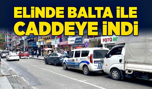 Elinde balta ile caddeye indi