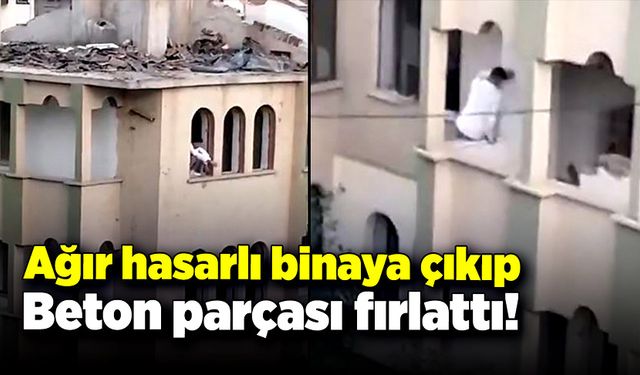 Ağır hasarlı binaya çıkıp çevredekilere beton parçası fırlattı!