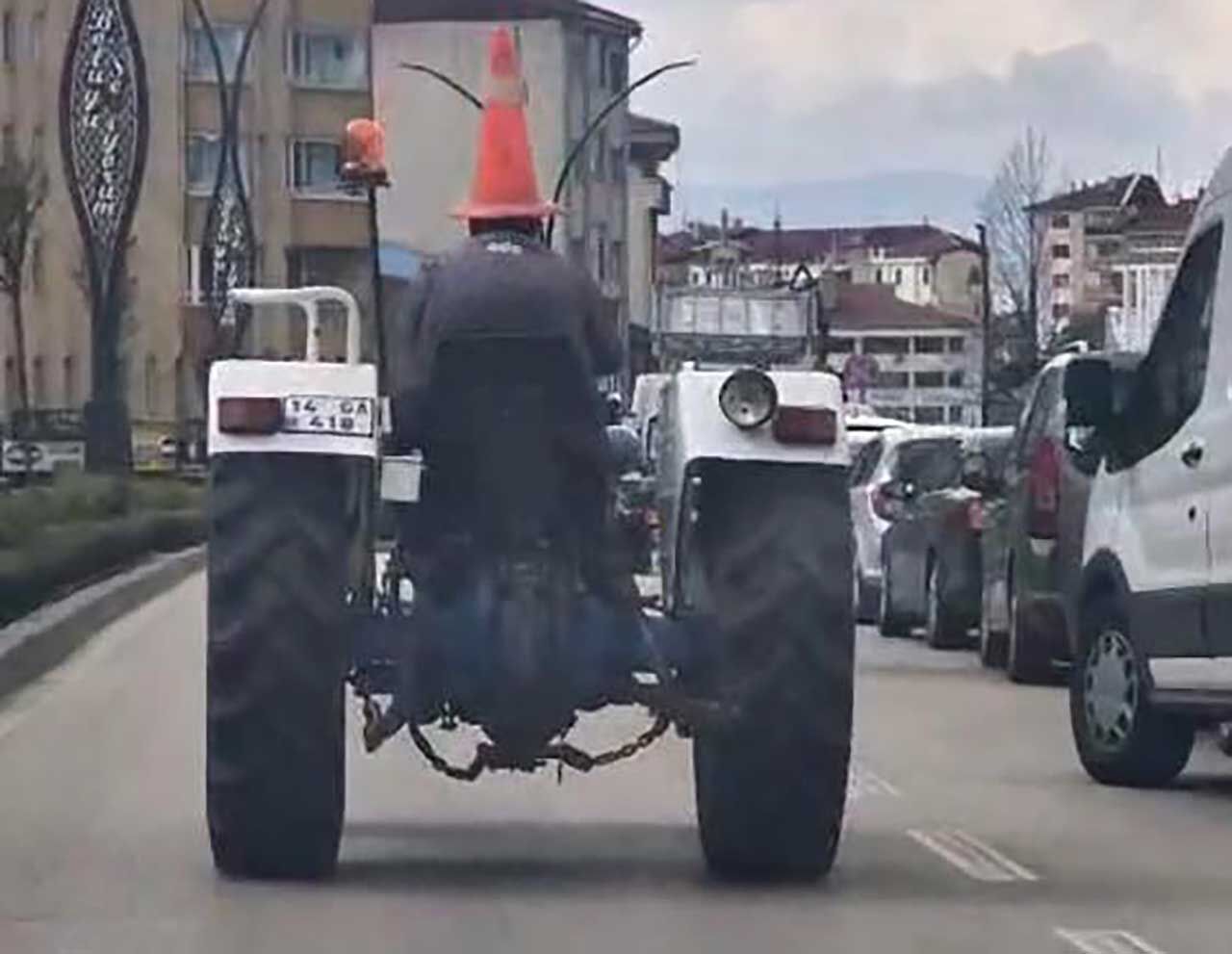 Bolu'da trafikte ilginç görüntü: Başına duba geçirip traktör sürdü